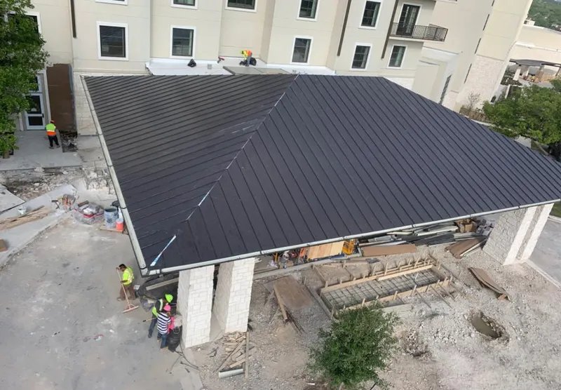 Metal roofing installation team working on a commercial building in Franklin
